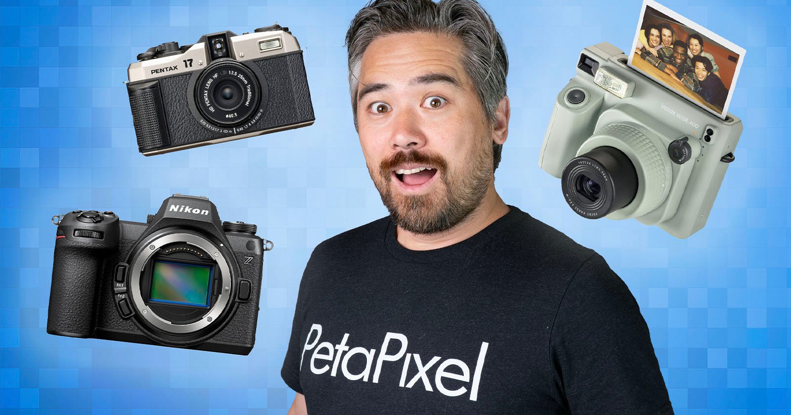 A man with a surprised expression, wearing a black "PetaPixel" shirt, is in front of a blue checkered background. Floating around him are three cameras: an old Pentax film camera, a modern Nikon DSLR, and a Polaroid instant camera with a printed photo.  .