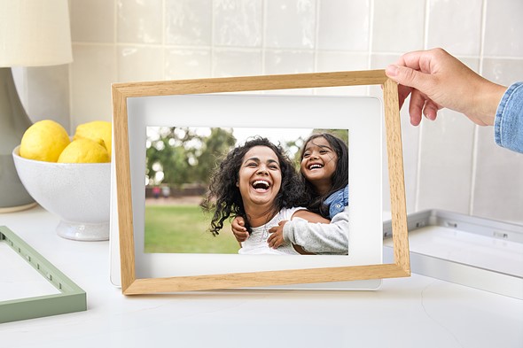 Image of someone swapping a wood frame on the Frame 2 for a plastic green one