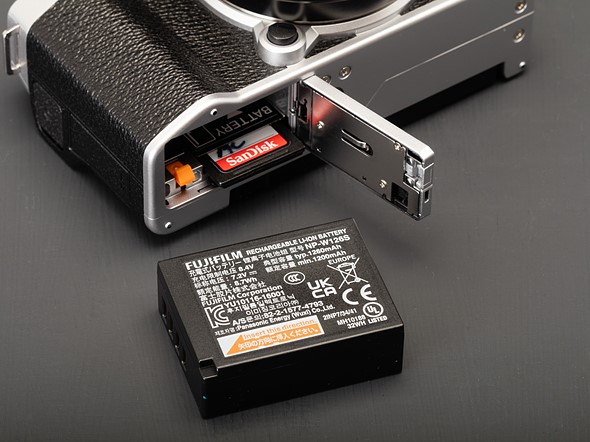 Picture showing the X-M5's battery door, with the SD card and battery sticking out