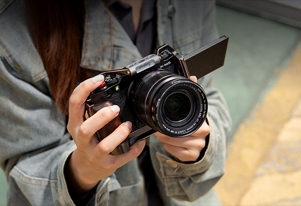 Photo of someone holding an X-M5 in a bronze and gold-accented cage