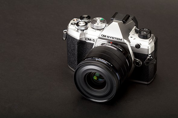 Photo of an OM System OM-5 against a grey background