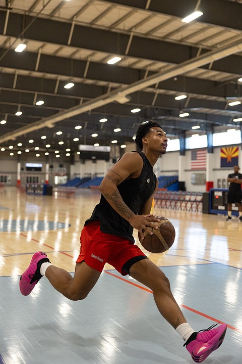 Wide angle photo of a basketball player driving to the basket