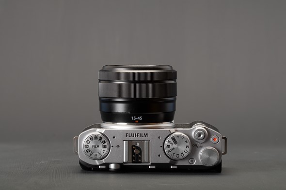 Photo of the X-M5's top plate, with three holes around the Fujifilm logo and hot shoe mount