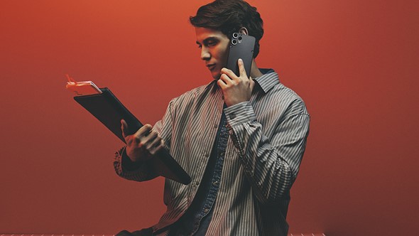 man_holding_cmf_phone_2_pro_red_background