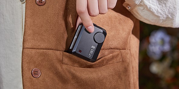 a hand puts the godox it30 flash in jacket pocket