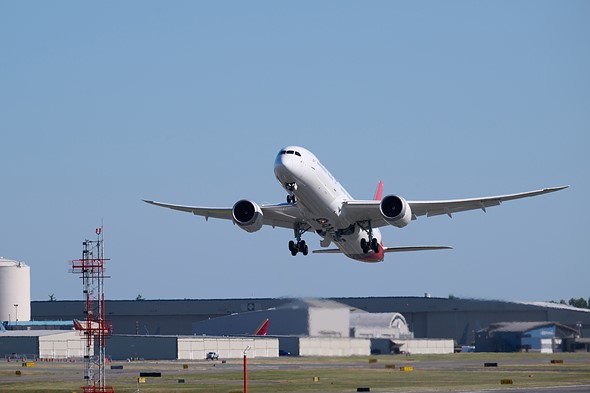 an airplane takes off at airport with blue skies