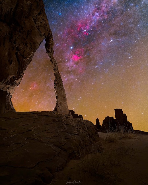 desert arch with milky way in night sky