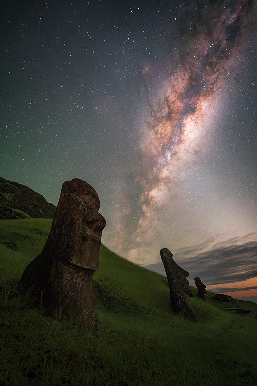 easter island statues in front of milky way
