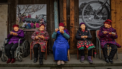 elderly women sit on porch enjoying food