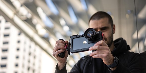 man holds phone with filmmaking cage