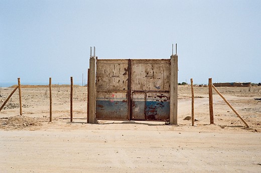 metal gate in front of barren desert