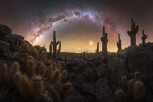 milky way stretches over desert scene-with catci