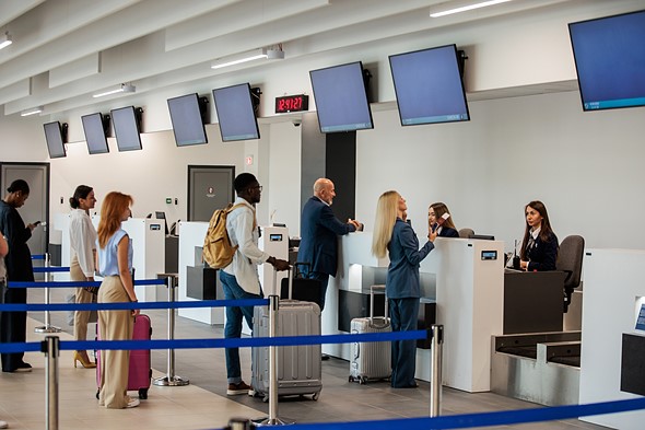 people stand in line at airport check in area