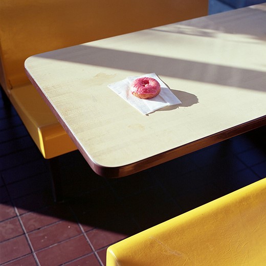 pink donut on diner table in light