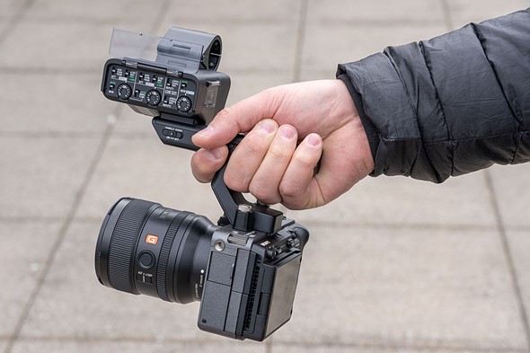Picture of the FX3 being held by a top-plate handle with the XLR acessory