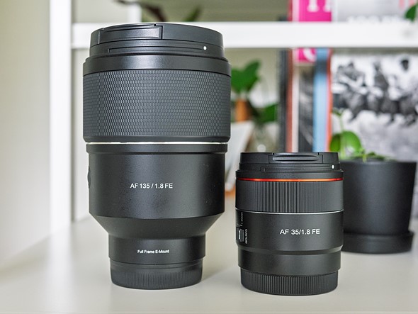 two prime lenses sit on white bookshelf