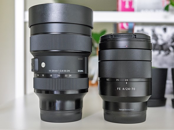 two zoom lenses are on white bookshelf