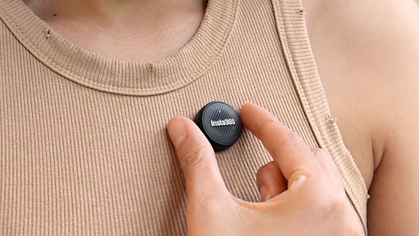 a hand adjusts the insta360 mic air on a tan shirt