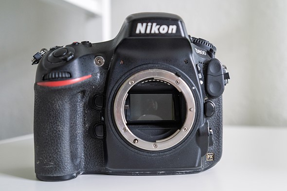 a nikon d800 sits on white shelf without lens