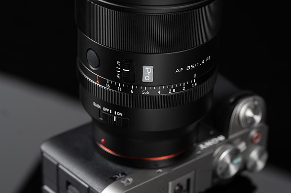 a viltrox 85mm lens is attached to sony camera sitting in front of a dark background