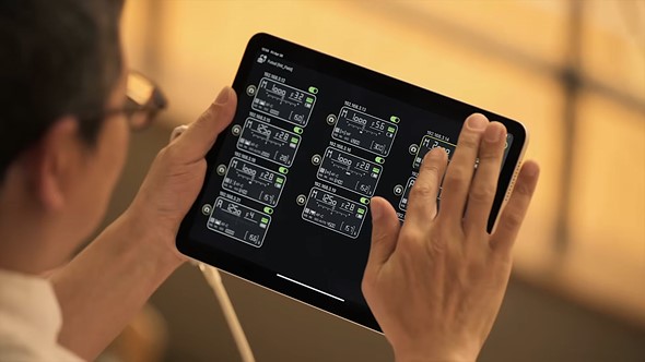 person holds ipad with camera controls on the display