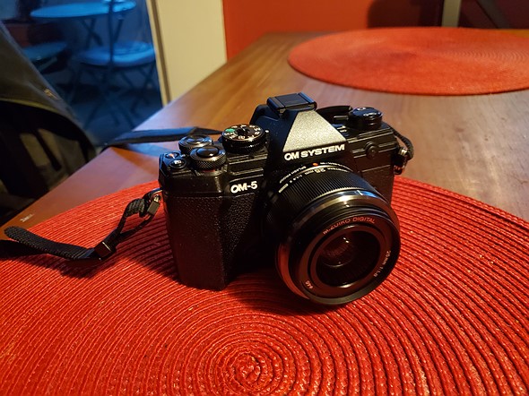 a black camera sits on a red placement on a table