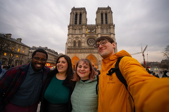 four tourists standing in front of notre dam