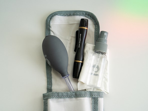 lens cleaning tools are placed on a white case on a white desk