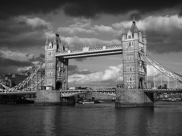 london bridge stands over the river with clousd in the sky