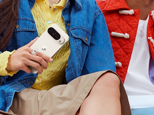 a persons hand holds a cream colored phone
