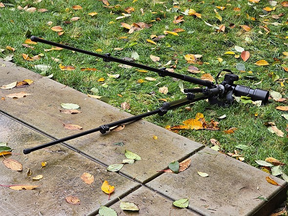 a tripod is on its side on grass after falling over