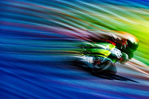 swirls of color surround a person on a motorcycle