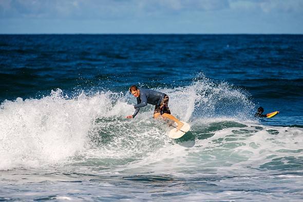 a man cuts back on a wave while surfing splashing water up