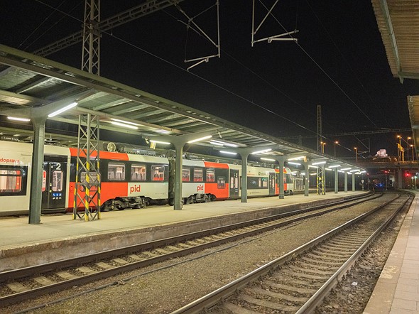 a train is in a station with empty tracks in front at night