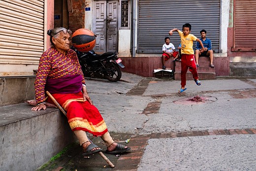 a basketball hits the face of an older woman with kids in the background