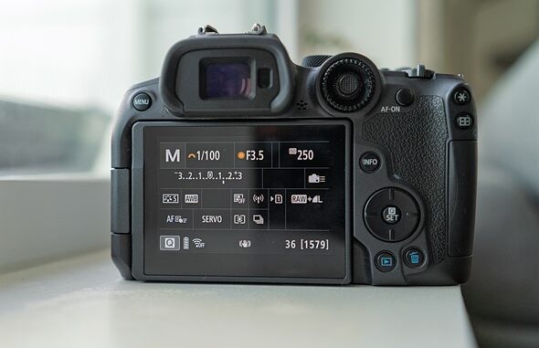 a_camera_with_the_display_on_sits_on_a_windowsill