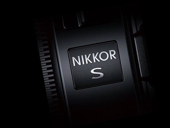 a lens with nikkor s on ts side is in dark lighting against a black background