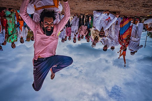 a man stands on his head in front of a crowd of people