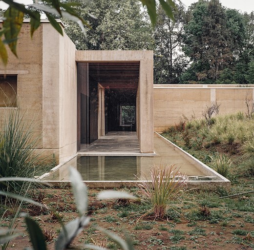 a modern building with strong rectangular lines is surrounded by vegitation