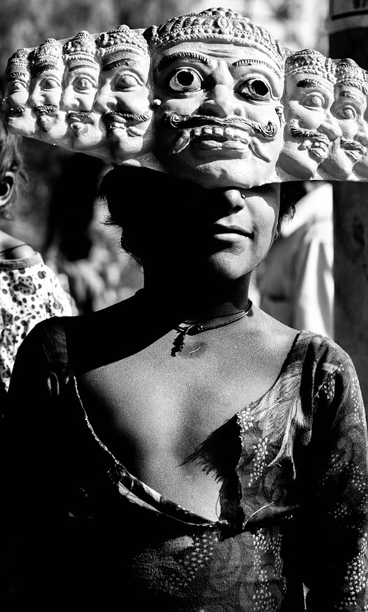 a person wears an elaborate mask with different faces 