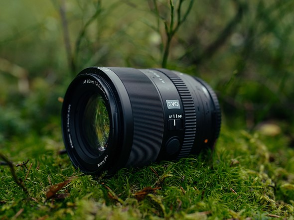 a viltrox lens sits on mossy ground