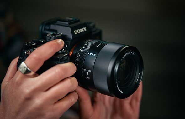 hands_hold_a_sony_camera_with_the_viltrox_85mm_lens