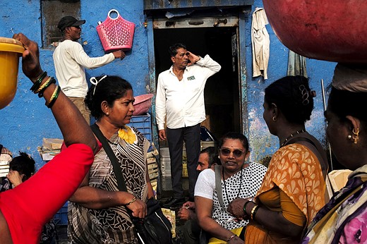 people crowd in front of a blue building