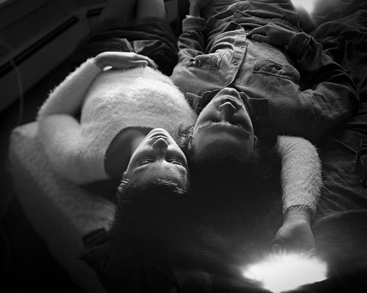 two people lie next to each other head to head