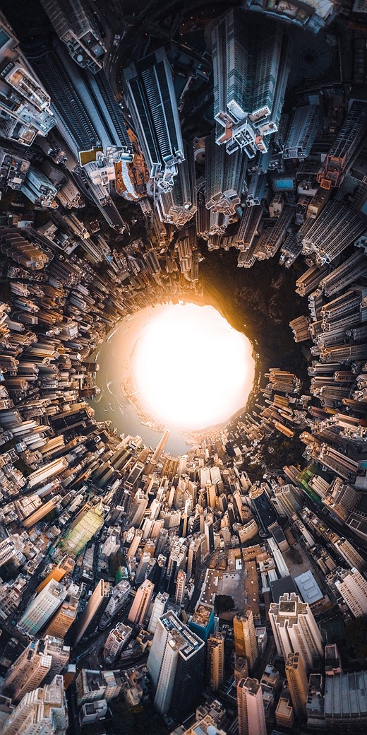 a dense cityscape is curved into a ricle around a glowing circle in the center