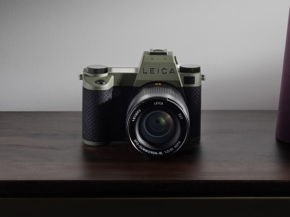 a green leica sl3 sits on a wooden table