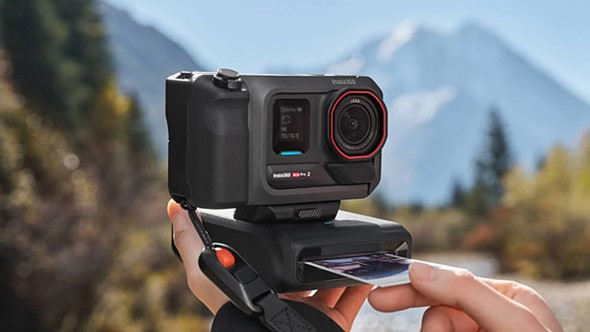 a_hand_holds_the_ace_pro_2_with_pocket_printer_in_front_of_a_mountain_and_river_1