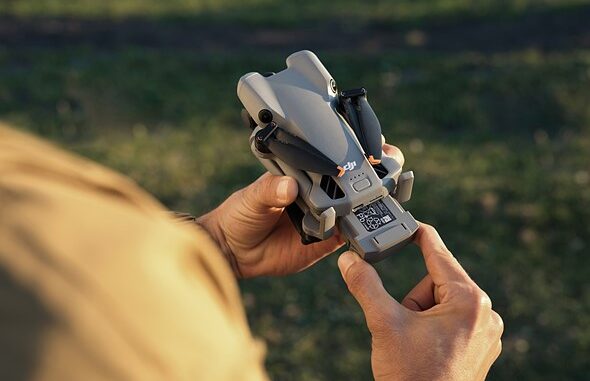 a_hand_pulls_out_the_battery_of_the_dji_mini_5_pro