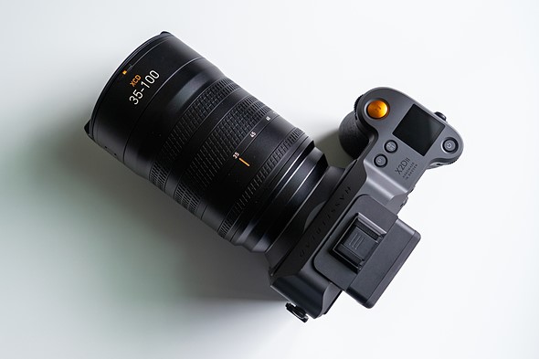 a hasselblad camera with lens is sitting on a white table  5 
