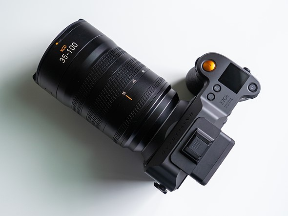 a hasselblad camera with lens is sitting on a white table  5 